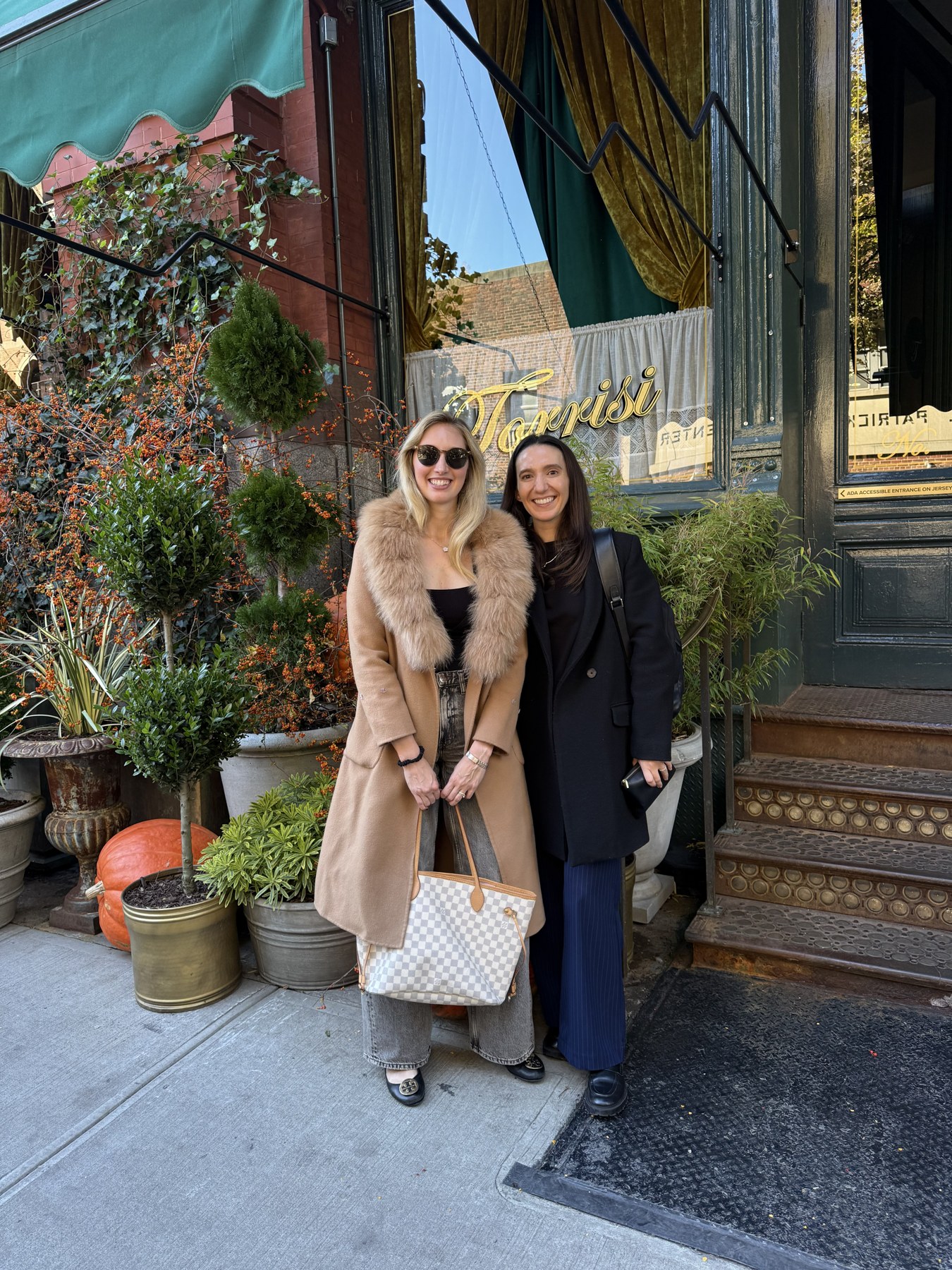 Two teammates smiling outside Torrisi in New York